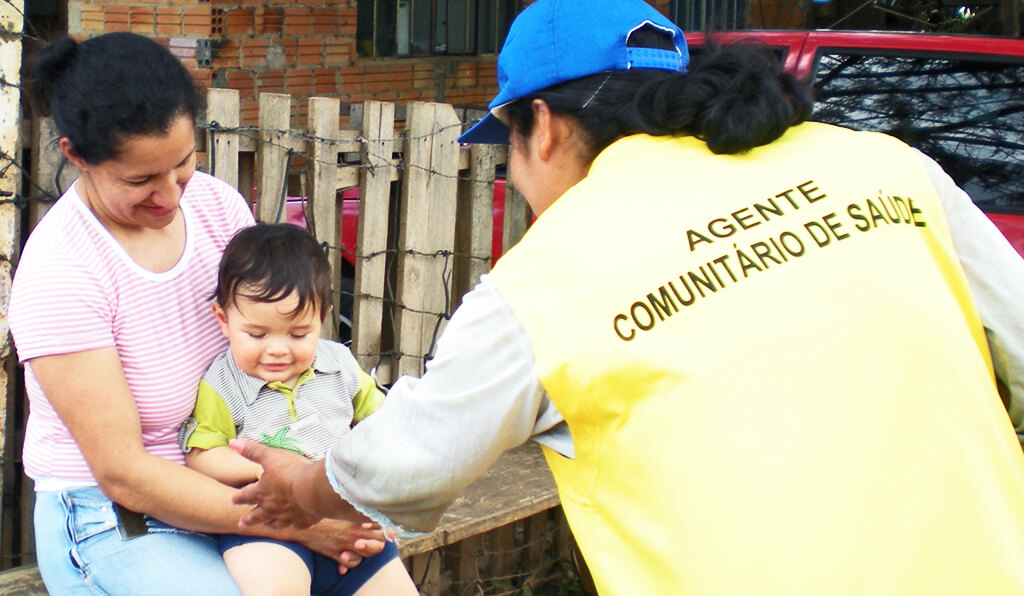 Agente comunitário de Saúde conversando com Mãe que carrega seu filho no colo, crédito da imagem para credito-Leticia-Scheifer